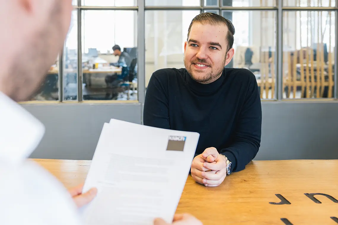 lachende man in gesprek met contract